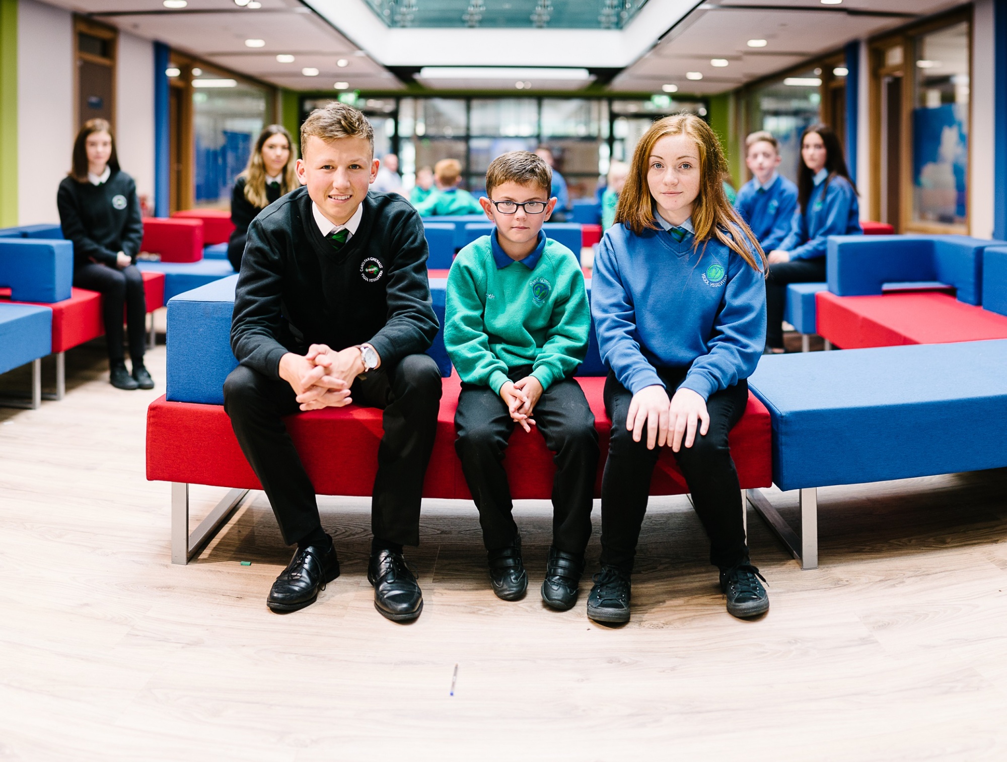 Photo of 3 pupils sitting in the atrium